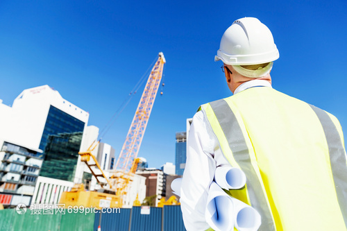 建筑工地的工程师建设者工程师建筑工人施工场景穿着带蓝图的安全背心